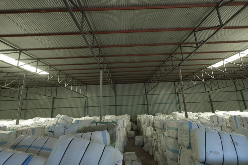 Rows of cloth bales with an aisle between them.
